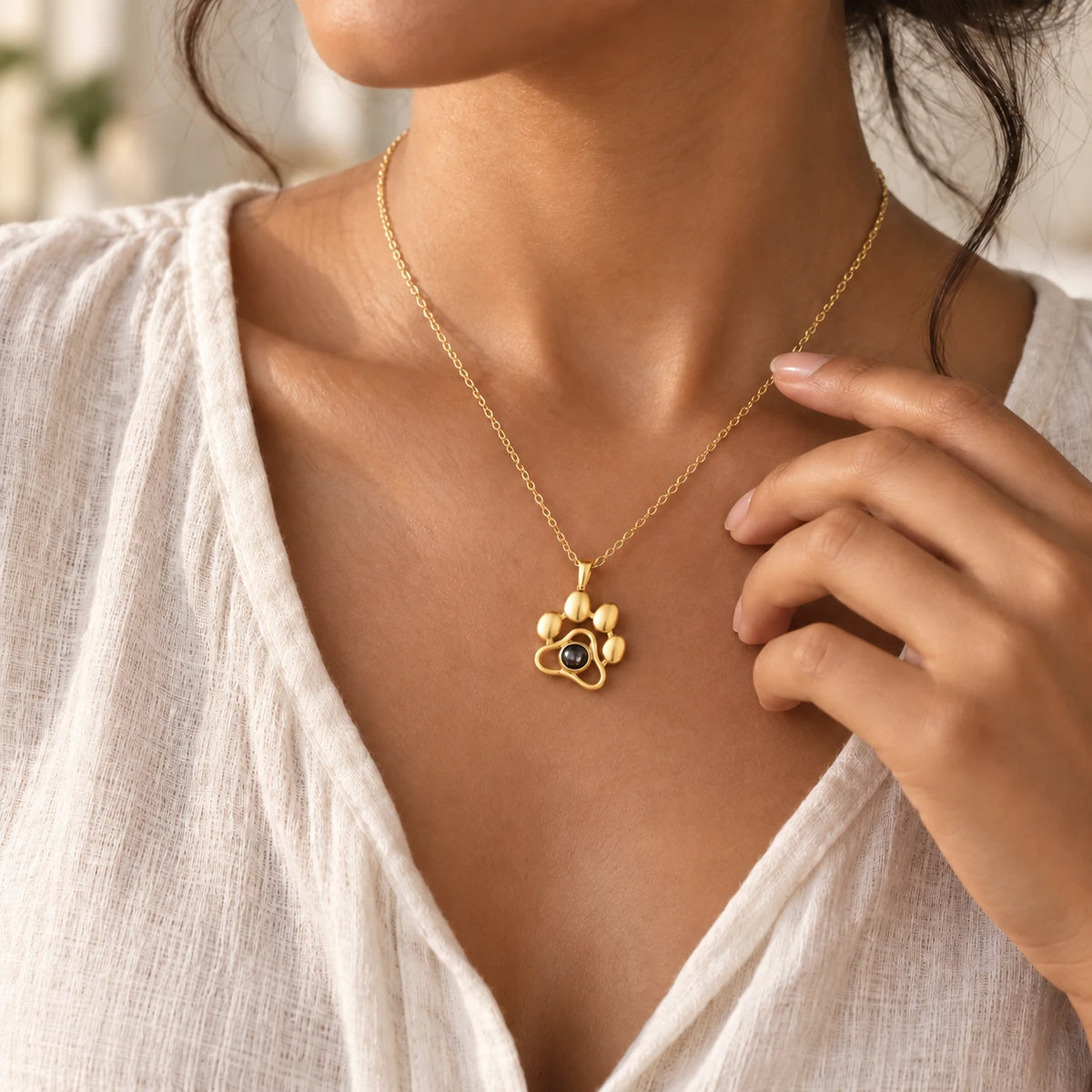 Paw pendant in gold-tone, worn on a chain