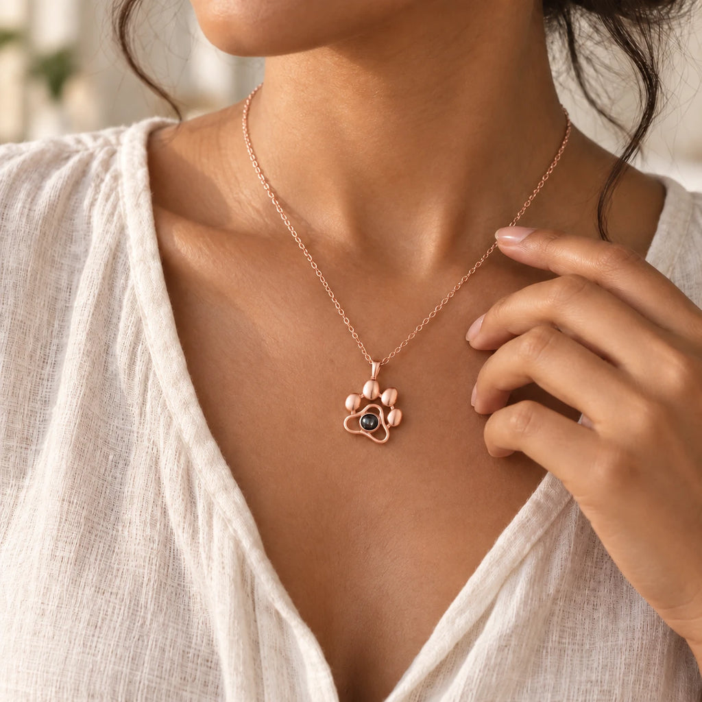 Paw pendant in rose-gold-tone, worn on a chain